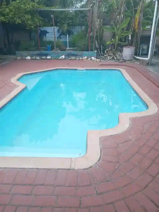 Clean blue swimming pool with a brick paved surround